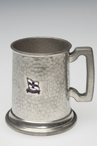 Silver souvenir tankard with flag decoration.