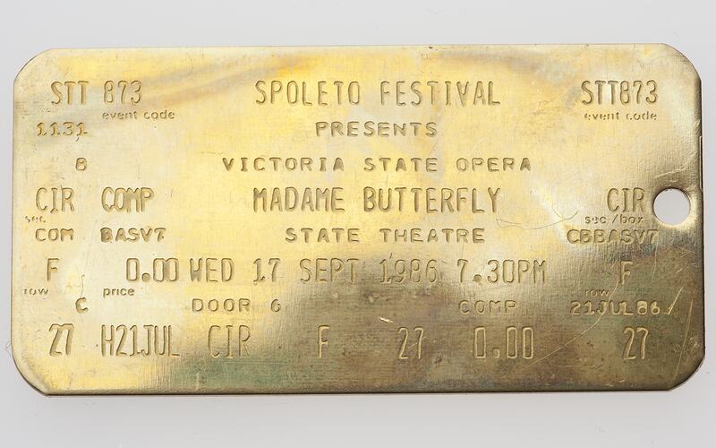 Gold metal ticket with stamped text.