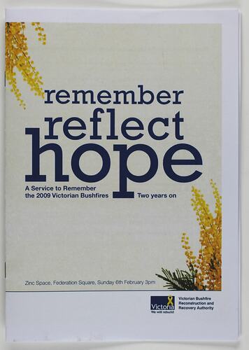 Program with white cover and blue printed text. Wattle flower detail top left and bottom right corner.