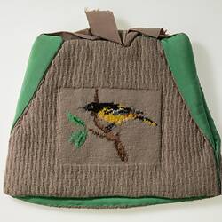 Tea cosy decorated with black and yellow bird.