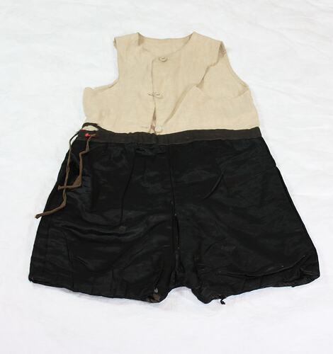 Black silk shorts, drawstrings on leg holes and waist. Shorts sewn onto cream cotton vest, sleeveless.