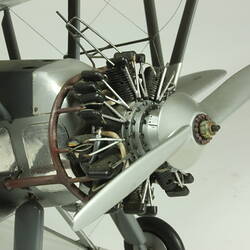 Silver model biplane model with red, white, blue rondels on wings and fuselage. Silver propeller. Propeller detail.