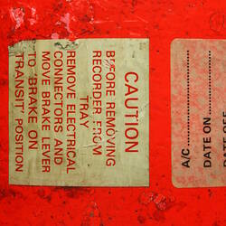 Red cylindrical container with two electrical cords at one end.