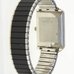 Watch, reverse. Black and silver rectangular face and flexible band.