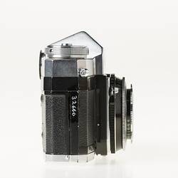 Black camera, metal top section. Dial top corner. Right profile.