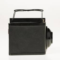 Black cube shaped all metal camera. Carry handle on the top plate. Right profile.