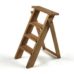 Toy wooden ladder, upright facing left.