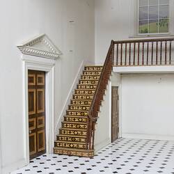 Doll's house interior room. Wooden parquetry staircase.