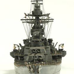 Naval ship with two masts, front view.