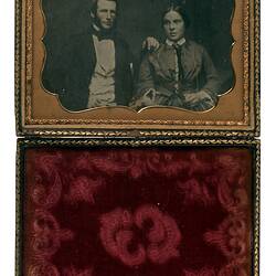 Portrait of man and woman in gold decorative frame with hinge attachment to red velvet section.