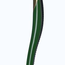 Titanium smooth, curved shard-like baton in dome-shaped stand. Green and gold sections on surface.
