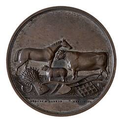 Round bronze medal with horse, sheep and bull. Below is a wheat-sheaf, plough scarifier and scythe.