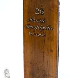 Timber sample with painted gold lettering.