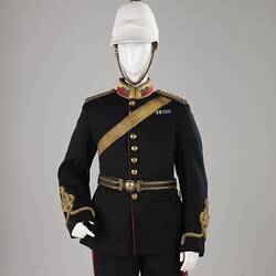 Navy officer's uniform with gold at cuff, epaulettes, belt. Brass buttons. Red/gold collar. White helmet.