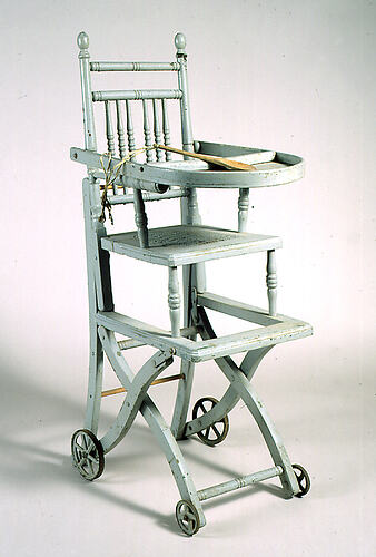 Painted high chair with turned wood construction.