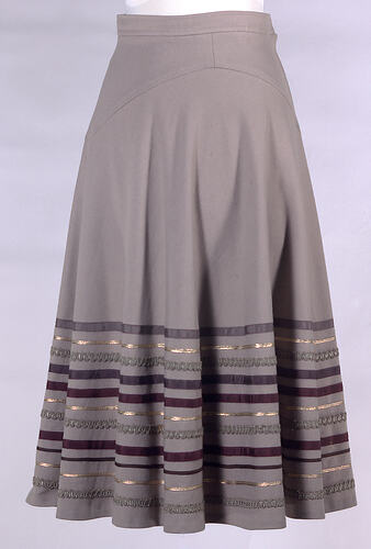 Beige wool skirt with ribbon decoration.