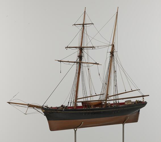 Black and brown sailing ship model. Two masts. Left profile.