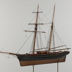Black and brown sailing ship model. Two masts. Left profile.