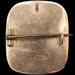 Back of square brooch with rounded corners. Gold back and horizontal pin.