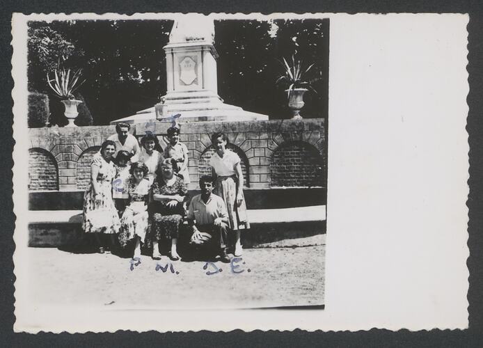 Family group posing in front of a cenotaph.