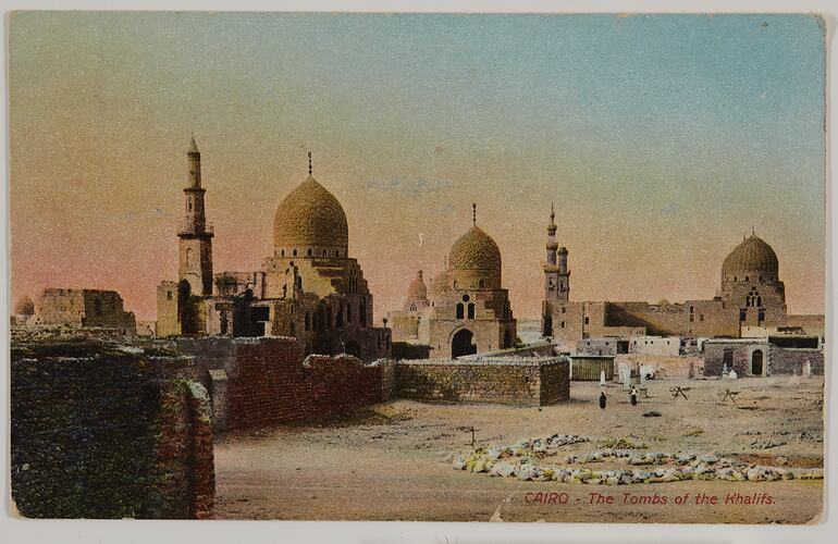 Mosque-like tombs with domed roofs in desert setting. Orange and blue sky.