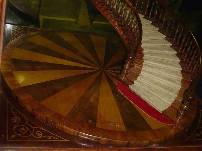 Model of a wooden staircase in a glass case.