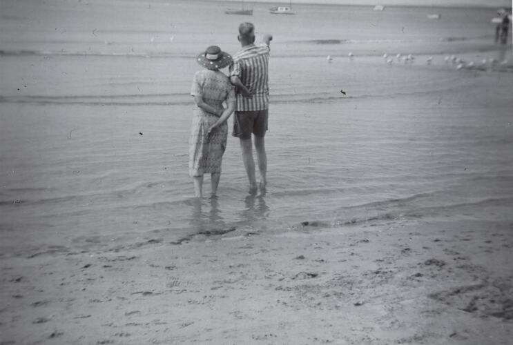 Digital Photograph - Man & Woman Standing on Beach, Pointing at Boats, Rye, circa 1960