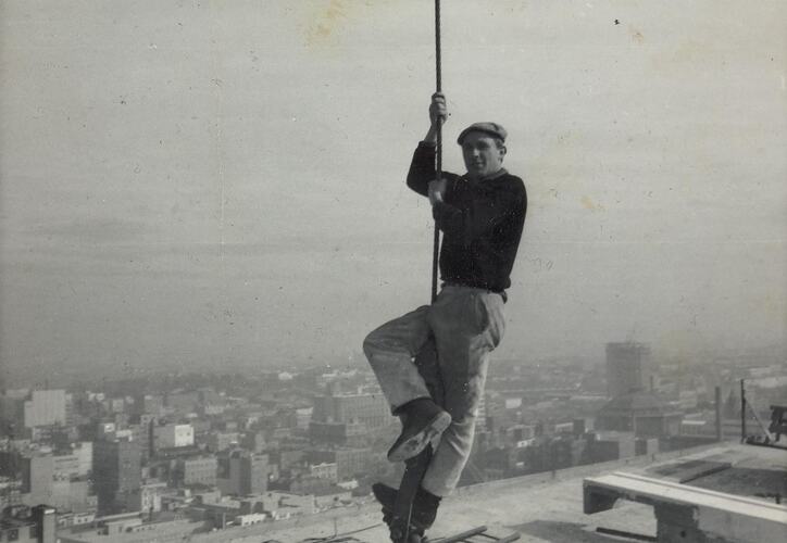Digital Photograph - Man Swinging from Crane Hook, Reserve Bank Construction Site, close view, Melbourne, 1964