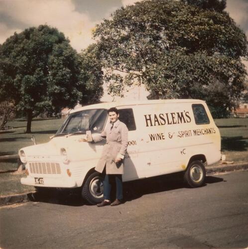 Digital Photograph - Man standing in front of 'Haslem's' Wine & Spirit Merchant Delivery Van, Yarraville, 1965
