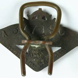 Triangular shaped metal pin, reverse side.