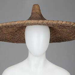 Wide brimmed coolie-type hat, with pointed centre peak.