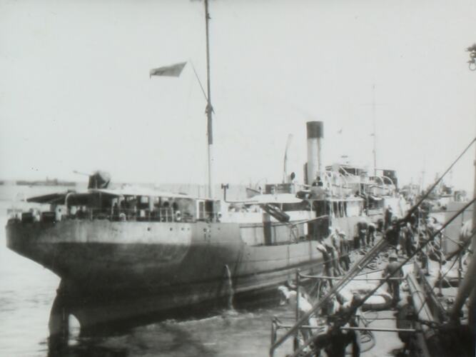 Side view of a navy ship, image taken from deck of another ship.