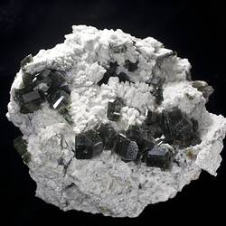 White rock with dark grey crystals on surface.