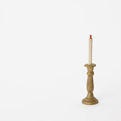 Gold coloured candle stick with white candle.