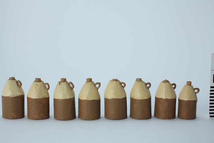 Brown and cream wooden jugs with handles.