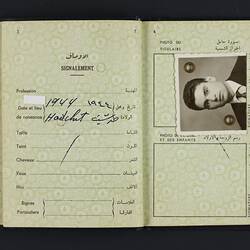 Open passport with white pages. Photo of young man. Printed and handwritten text.