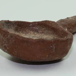Clay toy spoon, viewed from side.