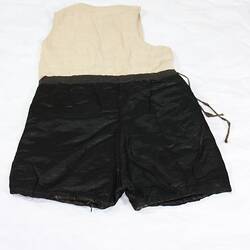 Back of black silk shorts sewn onto cream cotton vest, sleeveless.