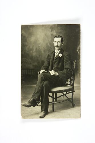 Portait of seated man wearing suit.