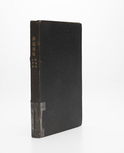 Worn black book. Three quarter view.