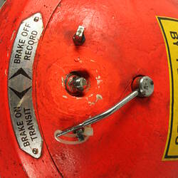 Red cylindrical container with two electrical cords at one end.