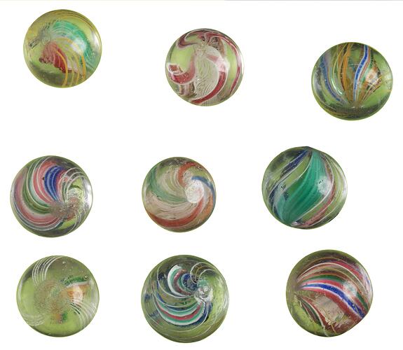 Nine glass marbles, each with a different coloured swirl.