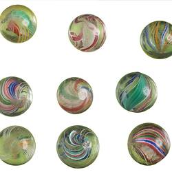 Nine glass marbles, each with a different coloured swirl.