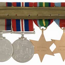 Group of four metals with ribbons joined together by metal pin.