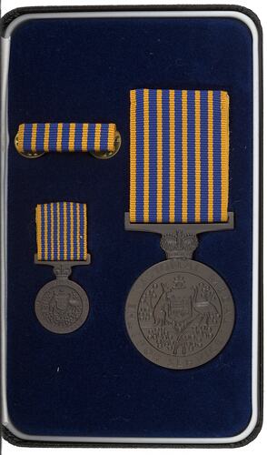 Two medals and one ribbon in blue fabric lined medal box.