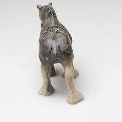 Back of fire affected brown and cream ceramic horse figurine.