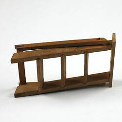 Toy wooden ladder, closed lying down.