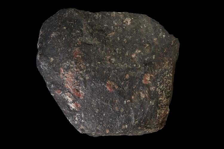 Rounded dark rock with orange patches.