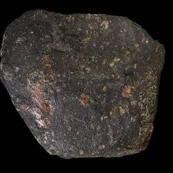 Rounded dark rock with orange patches.