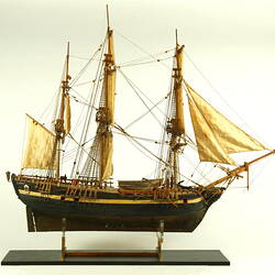 Wooden ship with three masts, facing right.